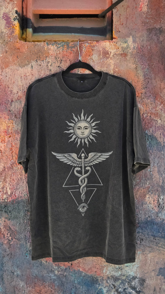 Inner Alchemy Fluffy Vintage tee hanging against weathered colorful wall showing caduceus print