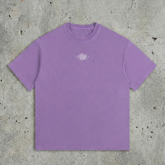 Purple t-shirt with a small logo on a concrete surface
