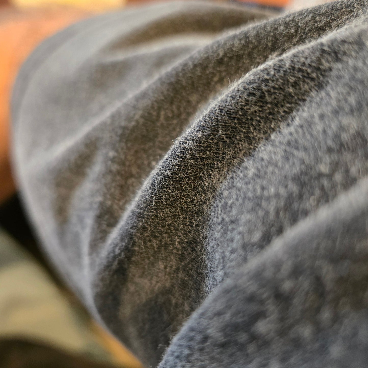 Close-up of dark gray vintage wash fabric showing soft faded texture and natural creasing