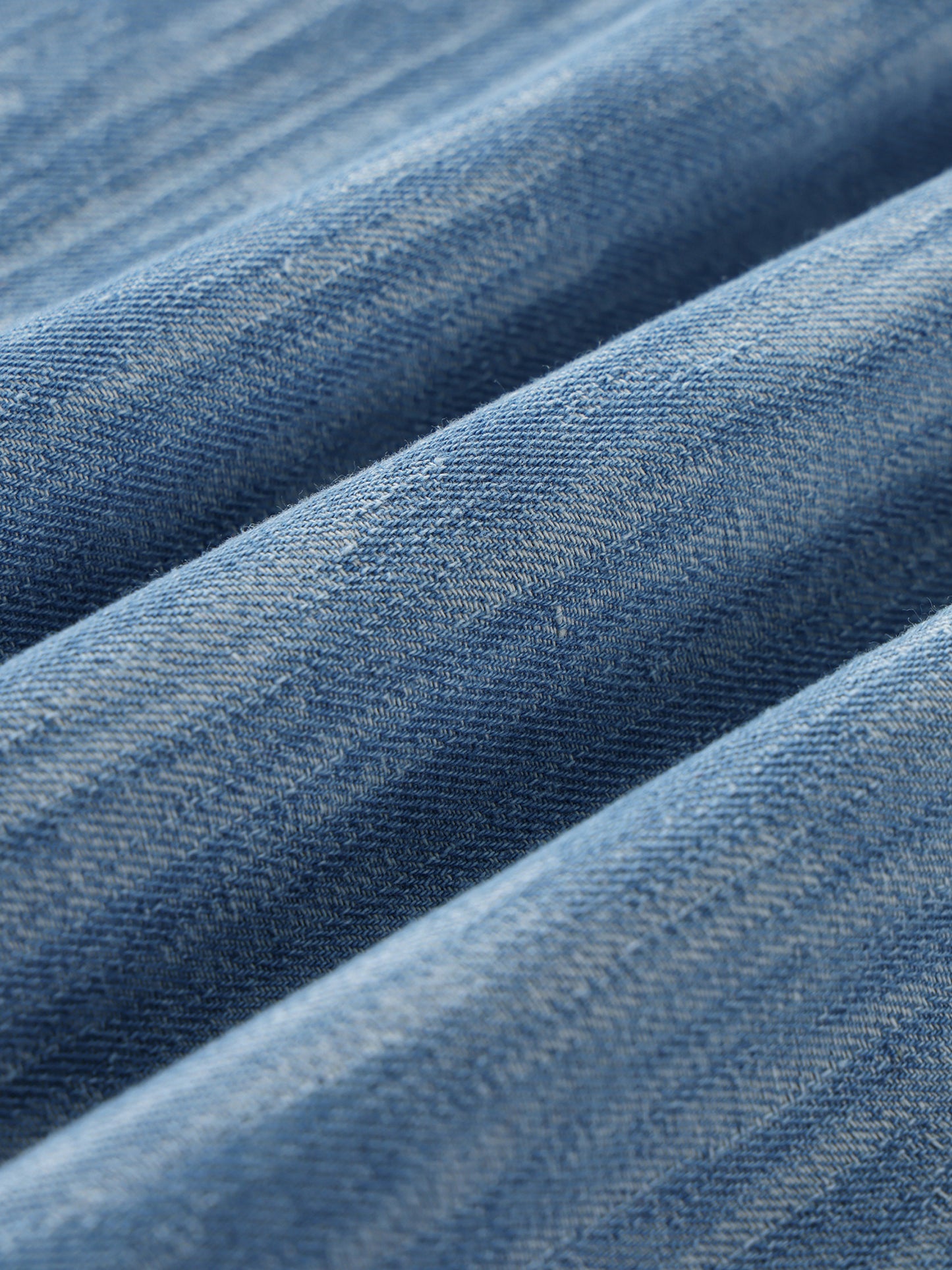 Dimensional Drift blue denim fabric close-up showing streaked wash texture