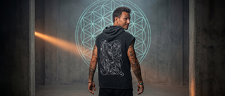 Back of the Embrace The Chaos snow washed boxy hooded tank with a serpent print, under a glowing Flower of Life projection