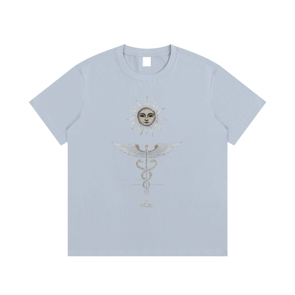 Light blue Inner Alchemy cotton tee flat lay with sun face caduceus and all-seeing eye print