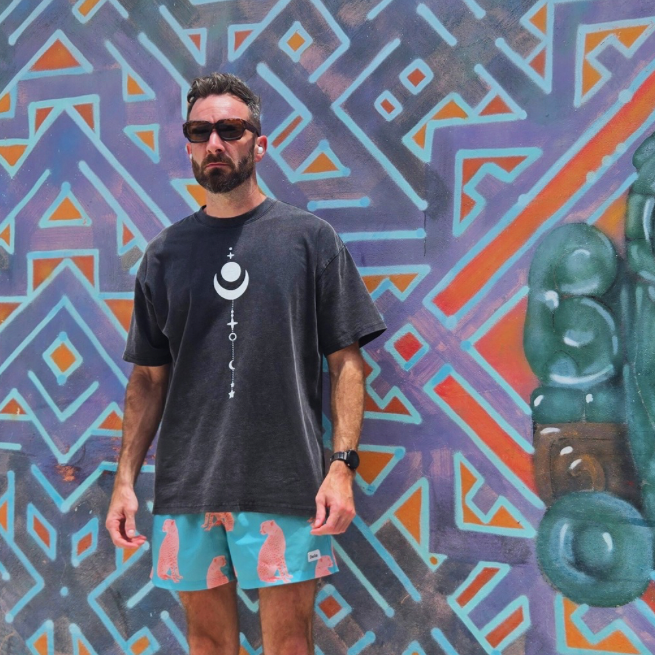 Model wearing Existential tee front view with moon phases chest graphic size L against mural