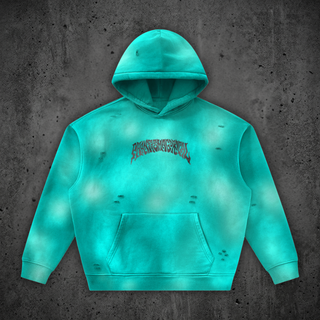 Front of the Enigma sunfade frayed fleece hoodie in Phantas Teal, laid flat on concrete, showing the cloud-faded wash, small fray openings across the body, kangaroo pocket, and the arched black Phantasmagorical wordmark on the chest