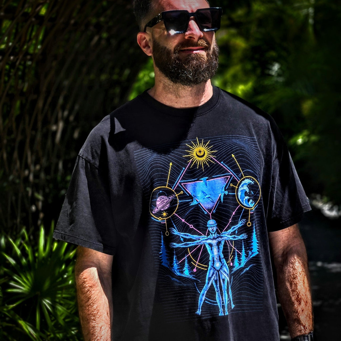 Man wearing a black t-shirt with a graphic design outdoors