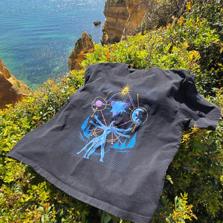 Interconnected charcoal vintage tee displayed on coastal cliff with ocean backdrop