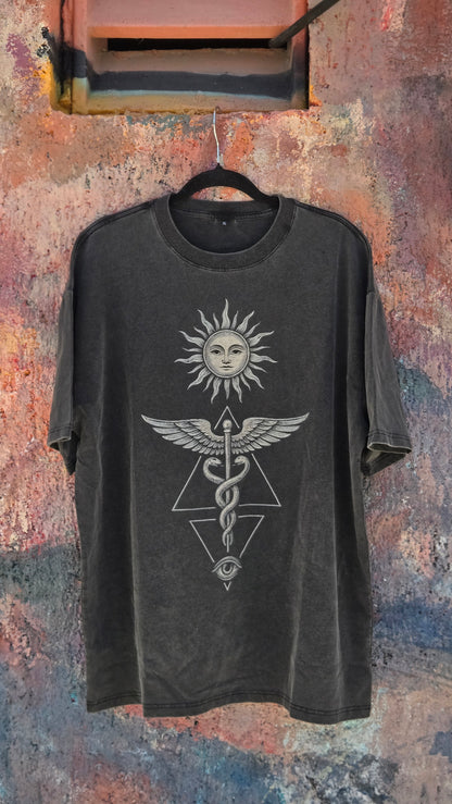 Inner Alchemy Fluffy Vintage tee hanging against weathered colorful wall showing caduceus print