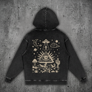 Mystic Signal Snow Wash Set hoodie in Black Beauty — charcoal snow washed heavyweight cotton hoodie laid flat on concrete, printed across the back in cream with a UFO beaming up a figure, an all-seeing eye pyramid, crescent moon and a desert of cacti and mushrooms.