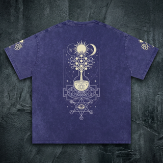 Indigo purple Celestial Synthesis snow wash oversized heavyweight tee, back view on dark stone, printed in cream with an alchemical flask, tree of life, sun, moon and sacred geometry.