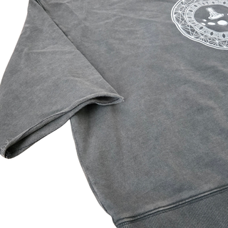 Close-up of the Paradigm mineral wash raw-edge tee showing the hand-cut raw edge and mineral wash texture