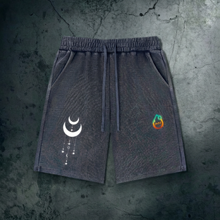 Charcoal Existential mineral wash waffle knit shorts on dark concrete, with drawstring waist, a small white crescent moon graphic on one leg and the colorful Phantasmagorical logo on the other.