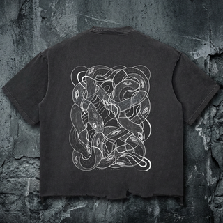 Charcoal gray Embrace The Chaos snow wash raw-hem boxy tee, back view on concrete, printed with white tangled serpent line art, a Phantasmagorical x Patakota collab.
