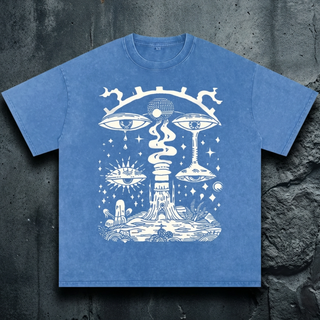 Cornflower blue acid wash Paradoxical Perspective oversized tee on concrete, printed in white with crying surreal eyes, a tree-stump temple, sun-eye and mushrooms.