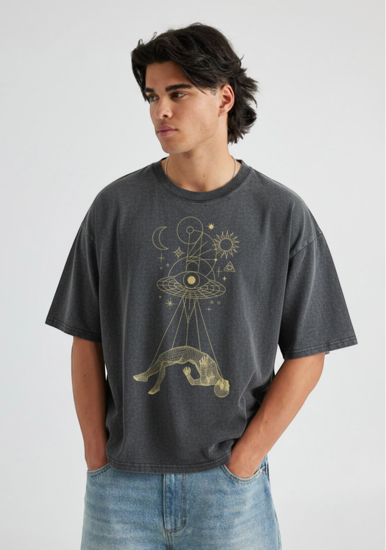 Model in Dimensional Drift charcoal tee with gold cosmic print paired with light denim