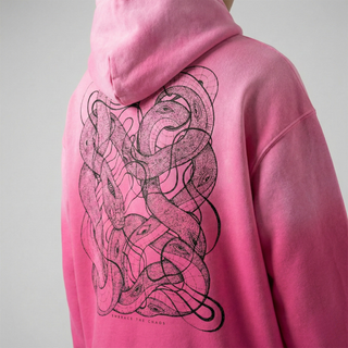Close-up of pink sunfade hoodie back showing black intertwined snakes and eyes graphic