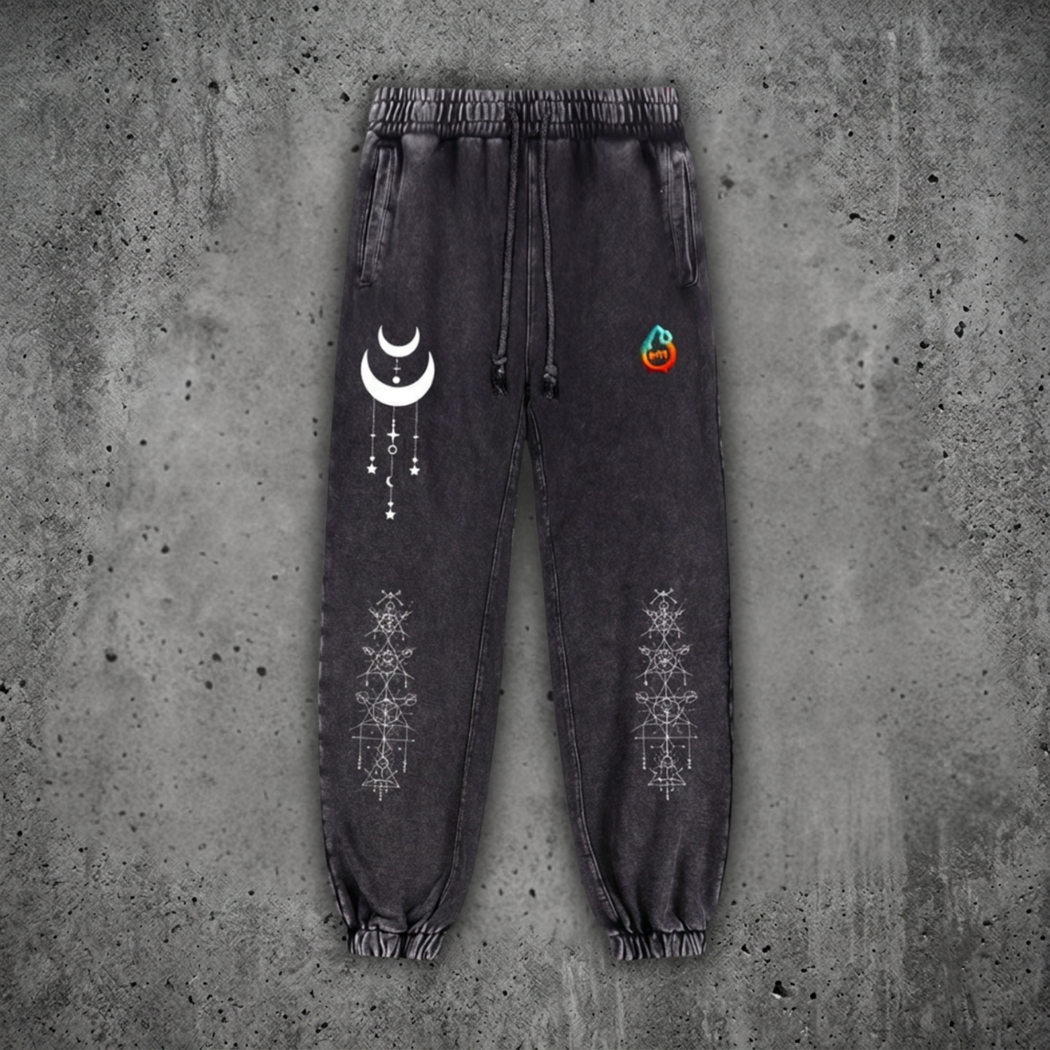 Charcoal snow wash Existential heavyweight joggers on concrete, with drawstring waist and cuffed ankles, printed with a cream crescent moon and white sacred geometry on the legs.