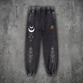 Charcoal snow wash Existential heavyweight joggers on concrete, with drawstring waist and cuffed ankles, printed with a cream crescent moon and white sacred geometry on the legs.