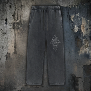 Charcoal snow wash Merkaba Cipher baggy heavyweight sweatpants on cracked concrete, with drawstring waist and a small white sacred geometry merkaba graphic on the thigh.