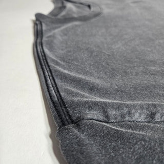 Close-up of Dreamstate tee side seam detail showing charcoal snow wash finish