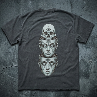 Charcoal Metamorphosis fluffy vintage washed tee, back view on dark slate, printed in cream with a surreal vertical stack of a third-eye skull and two nested serene faces.