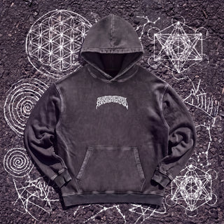 Front of the Cosmic Geometry snow washed heavyweight cotton hoodie in Dark Gray, styled on dark asphalt covered in white chalk sacred geometry, showing the small white wavy Phantasmagorical wordmark arched across the chest and the kangaroo pocket.
