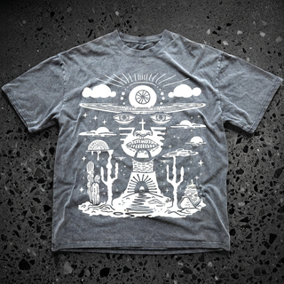 Gray Deserted Visions fluffy vintage heavyweight tee on speckled black stone, printed in white with a surreal third-eye face, UFO, clouds and a cactus desert scene.