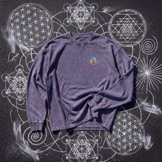 Front of the Dimensional Drift acid wash oversized long sleeve tee in Purple Haze, styled on dark asphalt covered in white chalk sacred geometry, with the Phantasmagorical logo on the left chest.