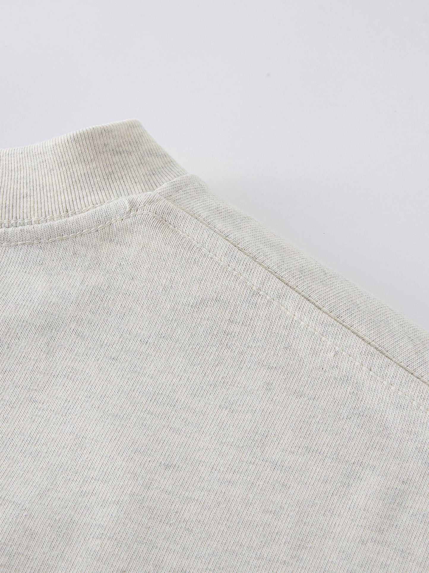Dissolve The Ego oat gray 425 GSM tee shoulder seam close-up showing reinforced stitching