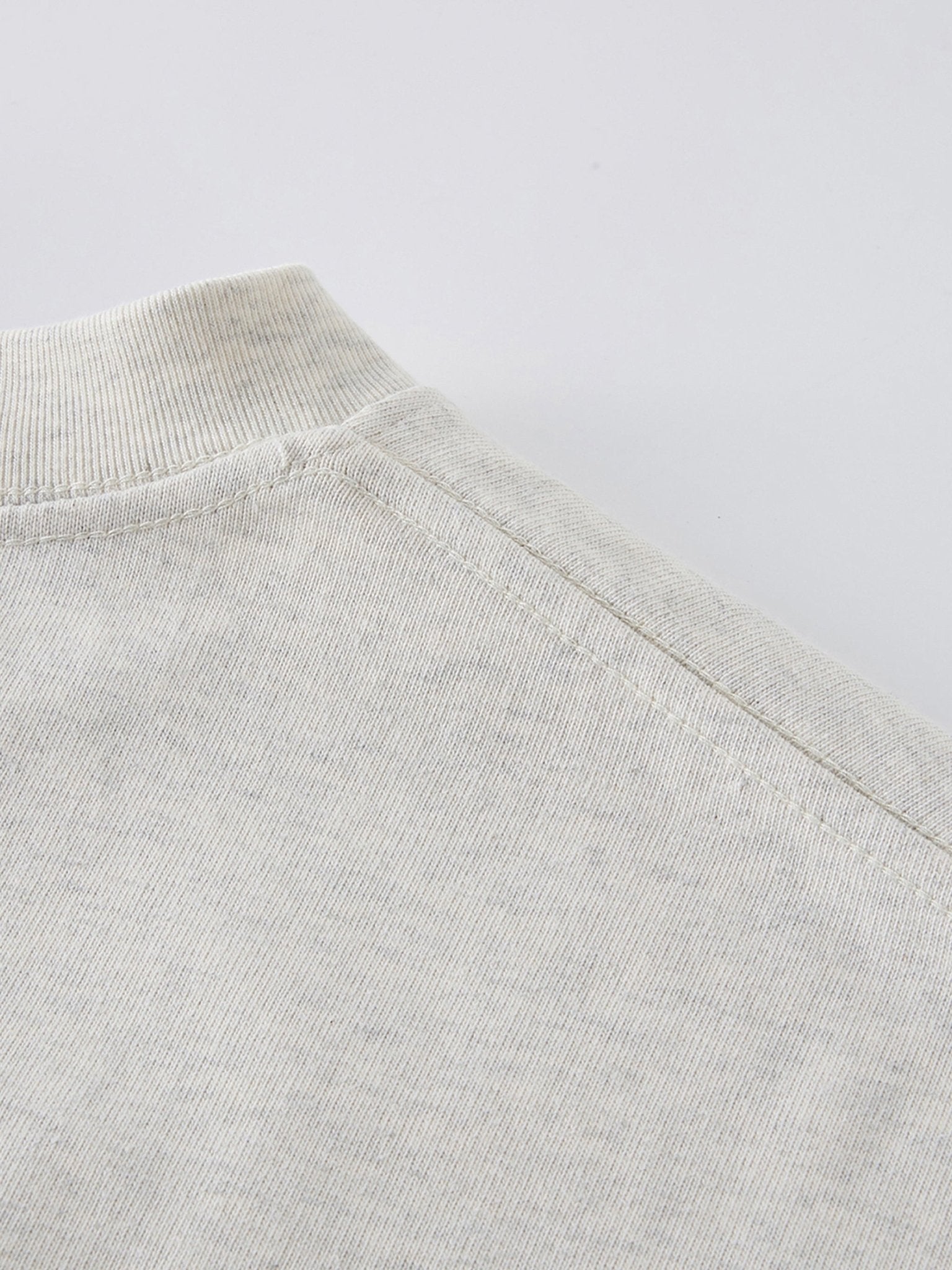 Dissolve The Ego oat gray 425 GSM tee shoulder seam close-up showing reinforced stitching