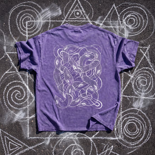 Back of the Embrace The Chaos Patakota collab tee in Purple Haze snow wash on chalk sacred geometry, printed in white line art with a dense tangle of intertwined serpents and eyes above the words Embrace The Chaos.