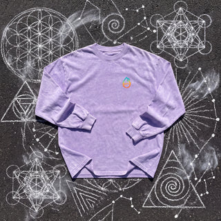 Front of the Existential acid wash oversized long sleeve tee in Purple, styled on dark asphalt covered in white chalk sacred geometry, with the Phantasmagorical logo on the left chest.