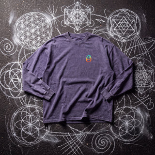 Front of the Existential acid wash oversized long sleeve tee in Purple Haze, styled on dark asphalt covered in white chalk sacred geometry, with the Phantasmagorical logo on the left chest.