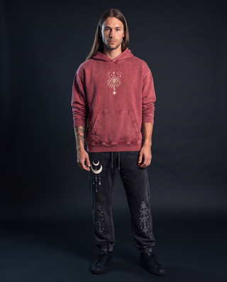 Model 6'0" and 165 lb wearing the faded red Mystic Signal snow washed heavyweight cotton hoodie with the cream all-seeing eye and moon printed centred on the chest, hood down, styled with charcoal Existential snow wash joggers with cuffed ankles.