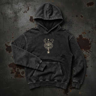 Black snow washed Mystic Signal heavyweight cotton hoodie crumpled into a styled flat lay on a warm grey studio sweep, one sleeve folded across the body and the hood standing soft, with the small cream all-seeing eye in a radiating triangle printed on the chest.