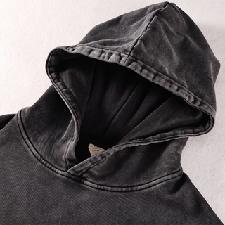 Close-up of the lined hood and neckline seam on the black snow washed Mystic Signal heavyweight cotton hoodie, showing the doubled hood edge, topstitching and mottled snow wash fading.