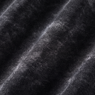 Macro view of the black snow washed heavyweight cotton on the Mystic Signal hoodie, showing the fine knit loops and the pale mineral wash gathering along the ridges of the folds.