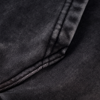 Close-up of the shoulder and raglan seam junction on the black snow washed Mystic Signal heavyweight cotton hoodie, showing the double rows of topstitching and the mottled snow wash.