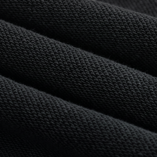 Macro of the 420 GSM heavyweight cotton knit grain on the black snow wash Existential joggers, raking light showing the loop structure.