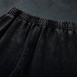 Close-up of the gathered rear elastic waistband on the Inner Alchemy heavyweight joggers, shot on dark charcoal concrete.