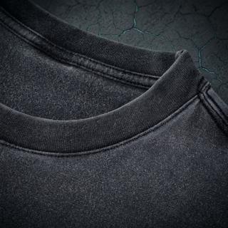 Close-up of the ribbed crew neck and reinforced double-stitch construction on the Existential fluffy vintage washed tee, shot on dark charcoal concrete.