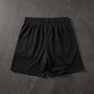 Back view of the black Nomenclature mesh drawstring shorts laid flat on dark stone, plain unprinted seat panel and elasticated waistband