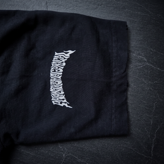 Close-up of the embroidered Phantasmagorical wordmark and hand-frayed raw sleeve edge on the tee included in the Existential x Paradigm Set.