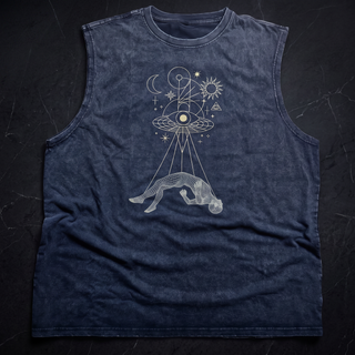 Dimensional Drift snow washed frayed hem tank top in charcoal mineral wash on near-black marble, printed in pale gold with a flying saucer eye beaming down onto a wireframe arched figure beneath a crescent moon, sun and all-seeing eye, with hand-frayed raw armholes.