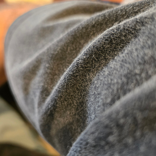 Close-up of soft fuzzy charcoal gray vintage-wash fabric texture showing fluffy napped surface
