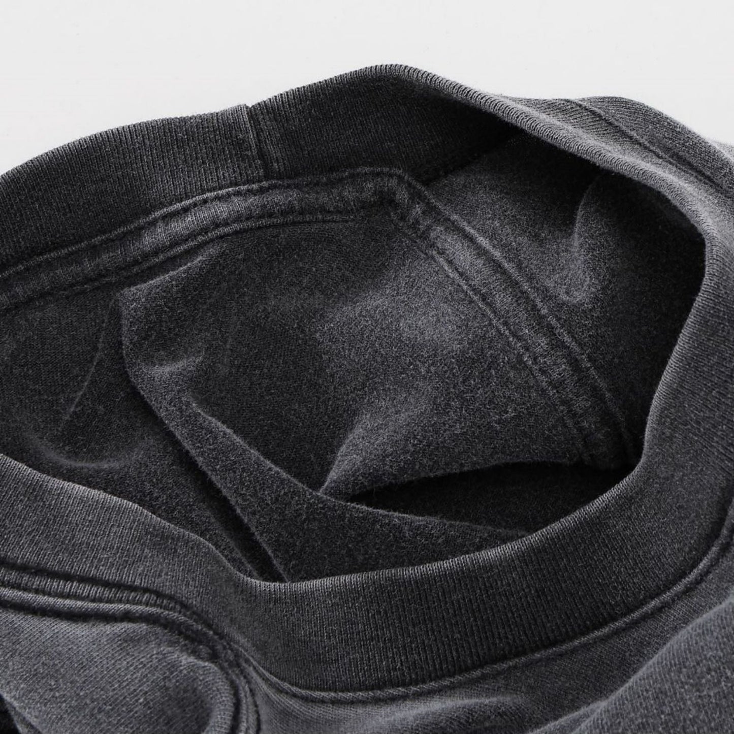 Close-up of charcoal vintage wash tee neckline showing ribbed collar and interior stitching