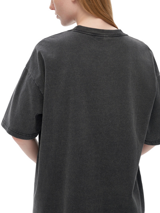 Woman modeling oversized charcoal Extraterrestrial vintage-wash tee from behind showing relaxed unisex fit