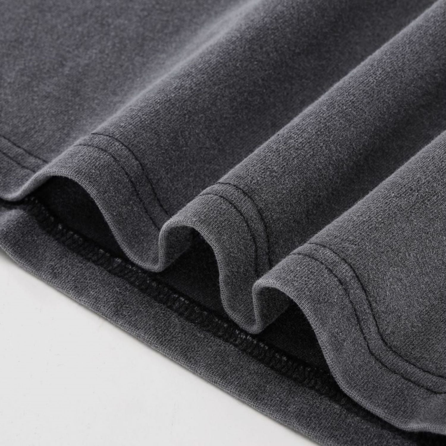 Close-up of charcoal Dimensional Drift fluffy vintage tee layered hem with double-stitch detail