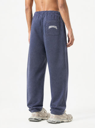 Back view of washed blue Spirit Molecule barrel leg sweatpants on model, rear patch pocket and relaxed wide leg