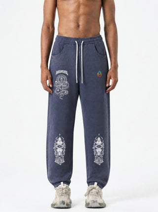 Model wearing Spirit Molecule barrel leg sweatpants in washed blue, front view with the wide open hem over sneakers