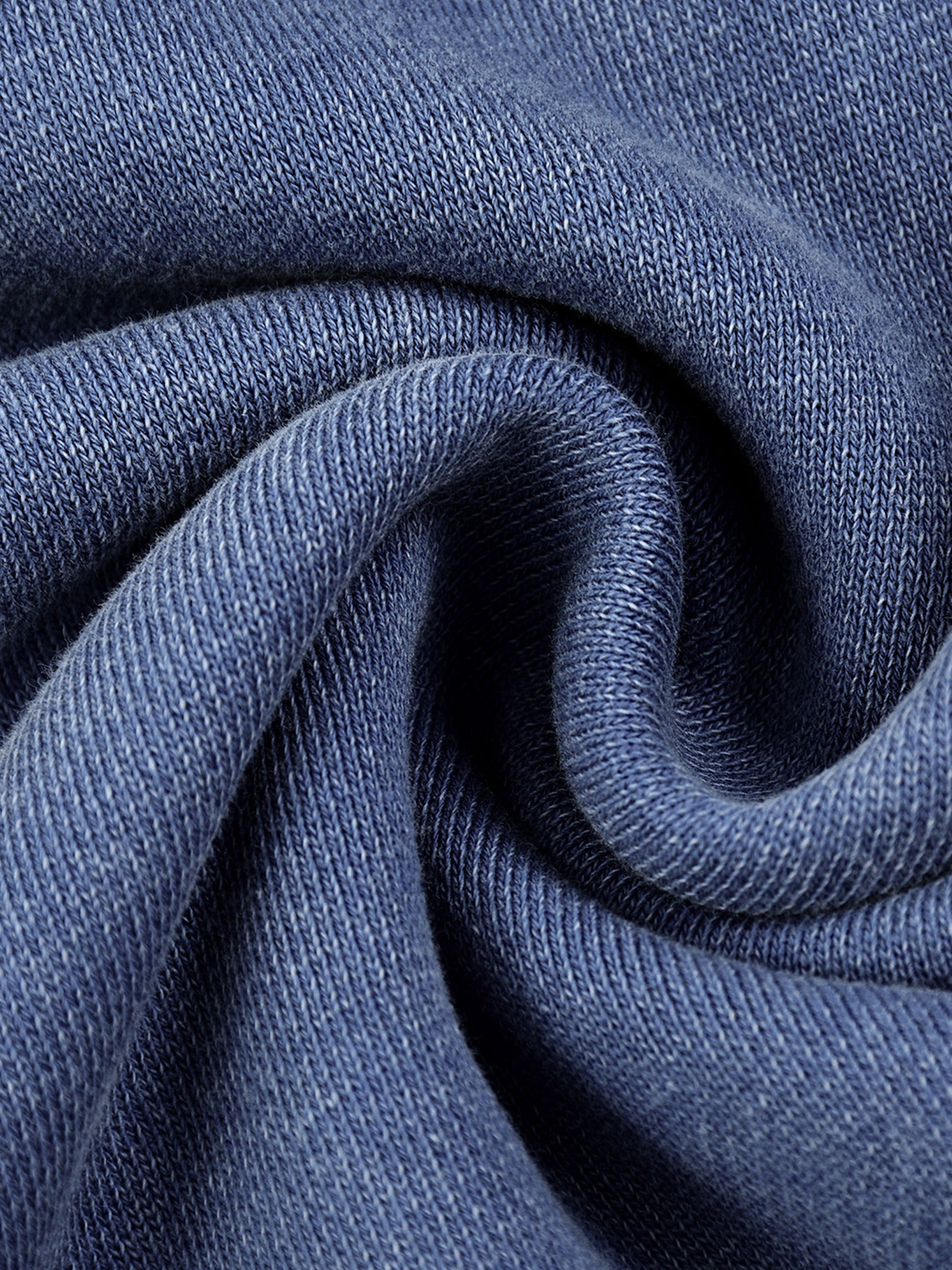 Close-up of blue Existential snow wash hoodie fabric swirled to show soft knit texture